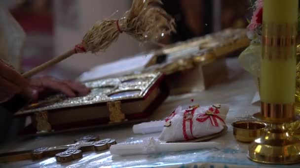 Anillos de boda en la Iglesia con el rocío de agua santa. — Vídeos de Stock