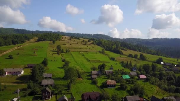 Vista aérea, casas de madeira no prado de declive em montanhas dos Cárpatos — Vídeo de Stock