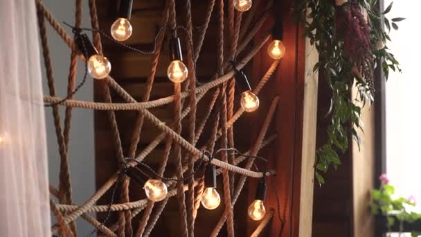 Ountry restaurant, wedding, wooden frame decorated with string lights hanging and glowing — Stock Video