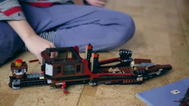 Çocuk tasarımcının ellerini topluyor.