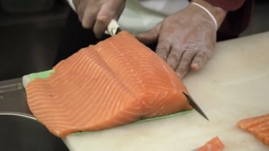 İşlem yapma ve kesme somon suşi için alır. İnce dilimler bıçakta tarafından kesmeye balık yemek.