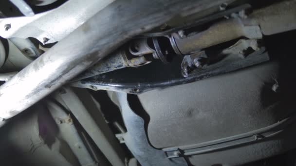 Profesionální automechanik šroubování detaily vozu se speciálním nástrojem na zvednutý automobil na opravy čerpacích stanic zblízka.