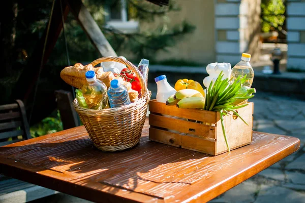 Social food kits for the elderly. A basket of groceries is on the table