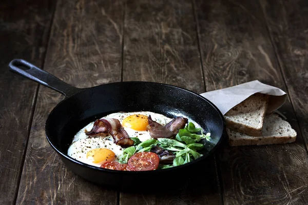 Завтрак готов. Пан из жареных яиц с беконом, помидор на деревянном фоне — стоковое фото