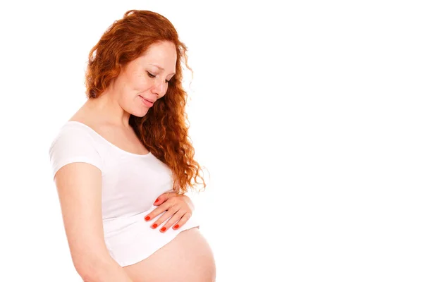 Mulher grávida abraçando a barriga e sorrindo . — Fotografia de Stock