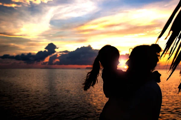 Silhouette di padre e figlia sulla spiaggia al tramonto . — Foto Stock