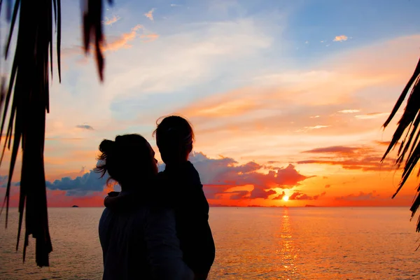 Baba ve kızı alacakaranlıkta sahilde siluet. — Stok fotoğraf