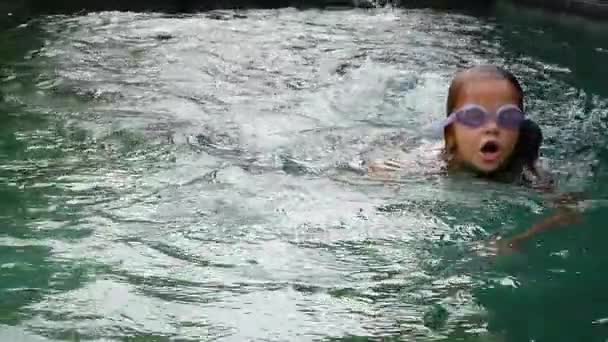 Маленькая девочка плавает под водой в бассейне. Slow Motion — стоковое видео