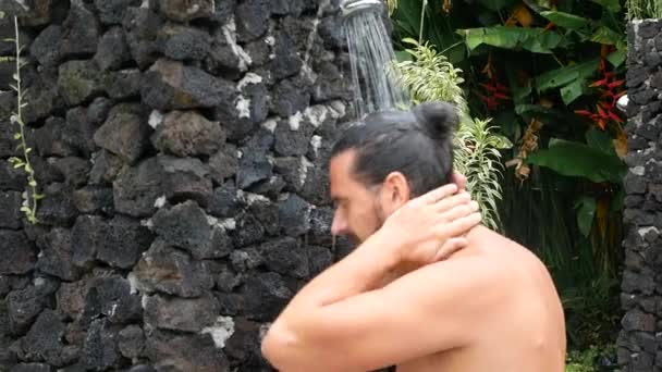 Чоловік миє обличчя під душем на відкритому повітрі, повільний рух — стокове відео