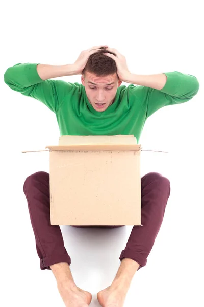 Surprised deliveryman hardly carries the parcel, isolated, white background — Stock Photo, Image