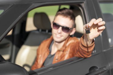 Araba anahtarları gösterilen genç adam