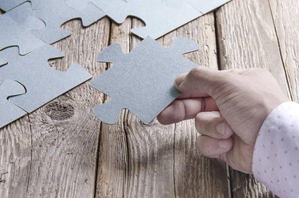 Niekompletne puzzle leżące na drewnianych deskach rustykalnych. — Zdjęcie stockowe