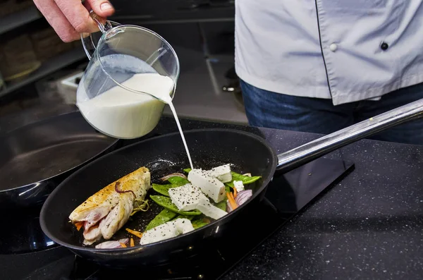 Chef preparing dishes in a frying pan — Stock Photo, Image