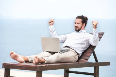 Dizüstü bilgisayar ile plajda işadamı serbest