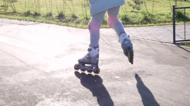 Маленька дівчинка вчиться кататися на роликах між конусами — стокове відео