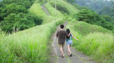 Koş çimenli ridge, tek palmiye ağacı önde, tropikal doğa ile yolu. Çift yürüyüş Ubud, Bali Adası.