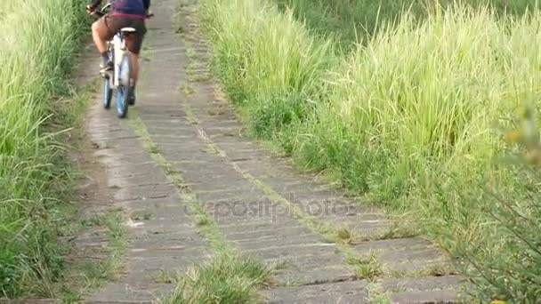 Bali: Mann rast mit Fahrrad durch Wiese — Stockvideo