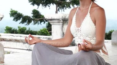 Kadın meditasyon yapıyor ve terk edilmiş tapınakta yoga yapıyor. Kadın pozu alıştırması