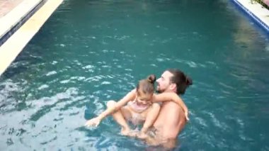 Mutlu aile, küçük çocuk, çok güzel yürümeye başlayan çocuk kızı havuzda eğleniyor ile etkin baba.