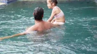 Mutlu aile, küçük çocuk, çok güzel yürümeye başlayan çocuk kızı havuzda eğleniyor ile etkin baba.