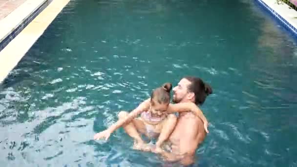 Boldog család, aktív apja kis gyermek, imádnivaló kisgyermek lánya, érzik magukat a medence. — Stock videók