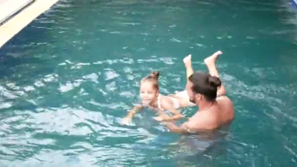 Mutlu aile, küçük çocuk, çok güzel yürümeye başlayan çocuk kızı havuzda eğleniyor ile etkin baba. — Stok video