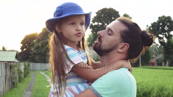 Padre divirtiéndose sosteniendo a su pequeña hija en brazos — Vídeo de stock