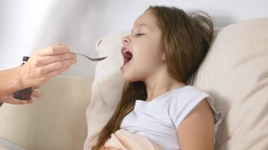 Anne ya da tıp hasta kızı yatakta şurubu veren doktor