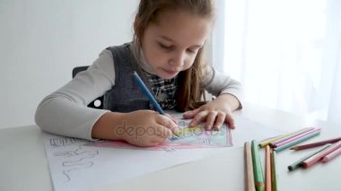 Küçük kız bir resim beyaz oda üzerinde çizim. 7 yaşında bir kağıda evde boyama ve çizim kız.
