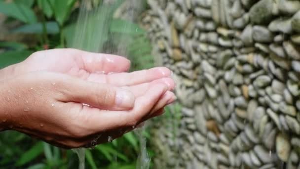 女性洗浄バリ島ジャングルの噴水の水のしぶきの下の手 — ストック動画