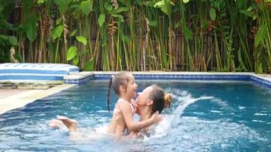 Mutlu anne ve kızı yüzme havuzunda eğlenin