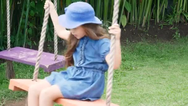 Menina europeia jogando baloiço de madeira com felicidade. Ásia, Bali. Indonésia — Vídeo de Stock