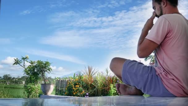 男はヨガ ロータスに坐っている緑の草の牧草地でポーズ、瞑想. — ストック動画