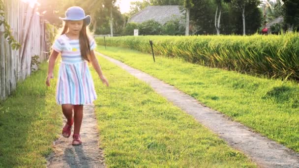 Маленька дівчинка весело біжить на сонці — стокове відео