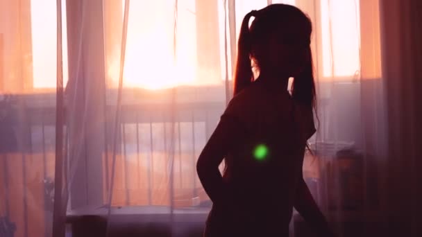 Happy child dansing, silhouette against window. long hair fly, girl feel good and excited — Stock Video