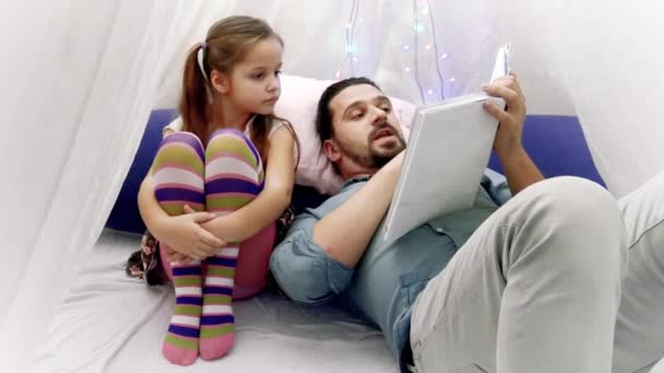 Gadis kecil dan ayahnya membaca buku bersama-sama — Stok Video