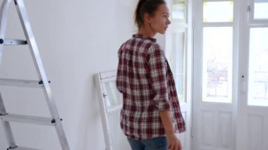 Woman thinks, plans, decides about repair her house, uses a tablet or mobile