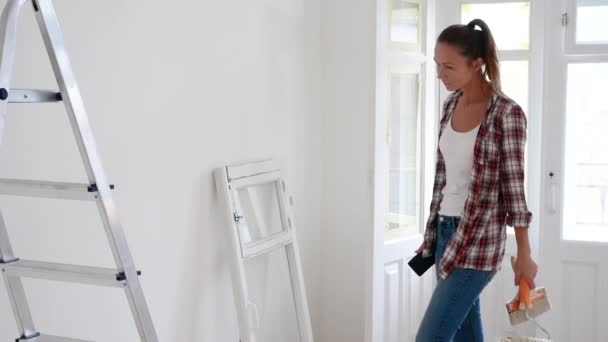 Mujer piensa, planea, decide sobre la reparación de su casa, utiliza una tableta o móvil — Vídeos de Stock