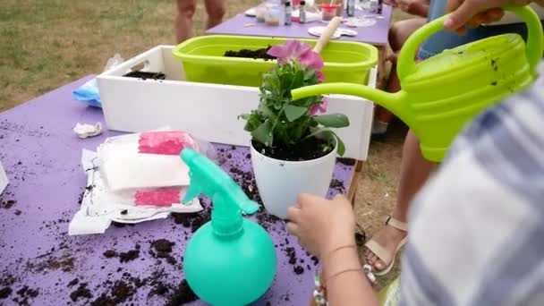 Gros plan de main enfant fille et mère plantation dans des pots de fleurs ensemble dans le jardin — Video