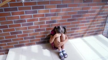 Child abuse. Little girl crying, sitting on the floor