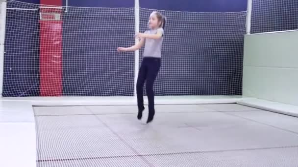 Klein kind meisje springen op trampoline en bungee in een game center. — Stockvideo