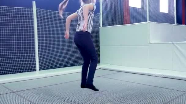 Petite fille enfant sautant sur trampoline et bungee dans un centre de jeu . — Video