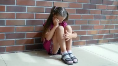 Child abuse. Little girl crying, sitting on the floor