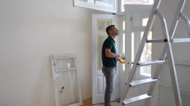 Kapıyı ya da pencereyi fırçayla boyayan adam. Lastik tamir ediliyor.