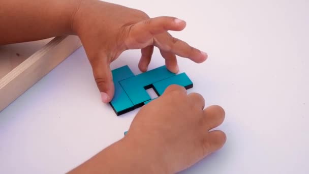 Концепція виховання дітей. Крупним планом повільний рух. Рука тримає шматок дерев'яного блоку головоломки. Концепція складного та розумного логічного мислення . — стокове відео