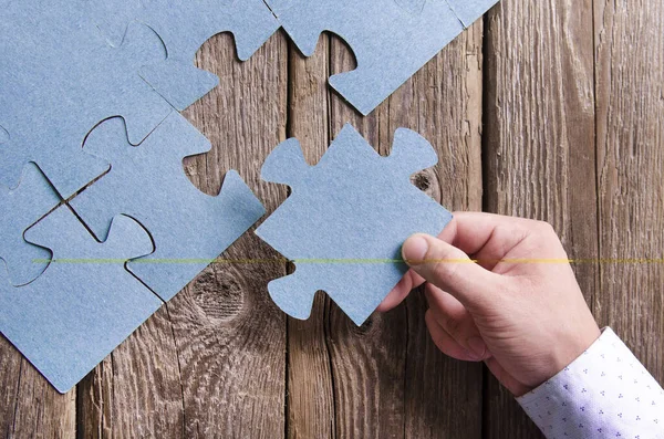 Niekompletne puzzle leżące na drewnianych deskach rustykalnych. — Zdjęcie stockowe