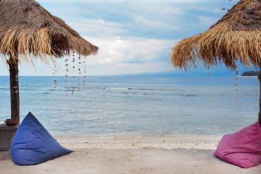 Deniz kıyısında şemsiye ve fasulye torbası..