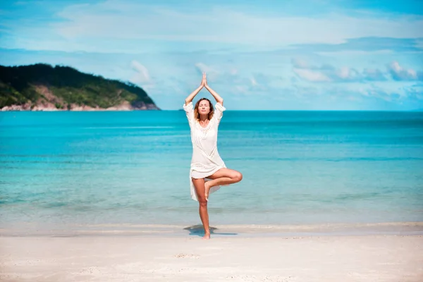 Genç kadın plajda yoga yapıyor. — Stok fotoğraf