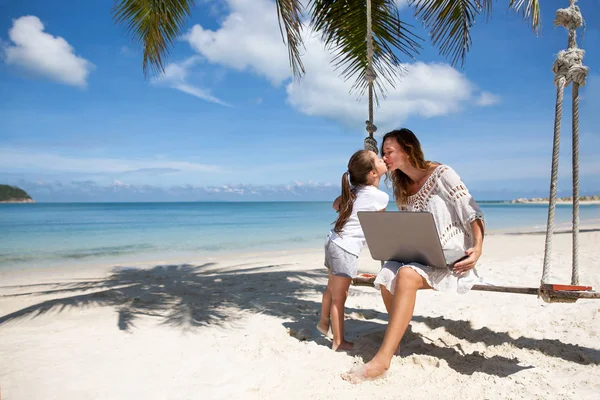 Women freelance on a beach with laptop