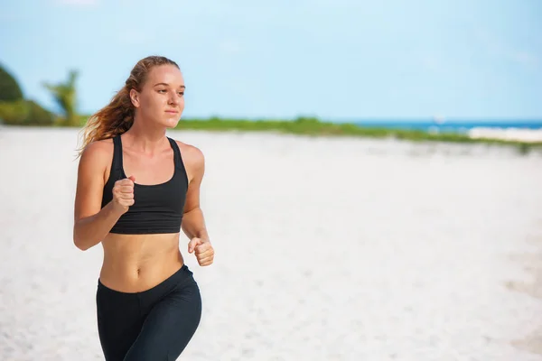 Young fitness woman running at beach — Stock Photo, Image